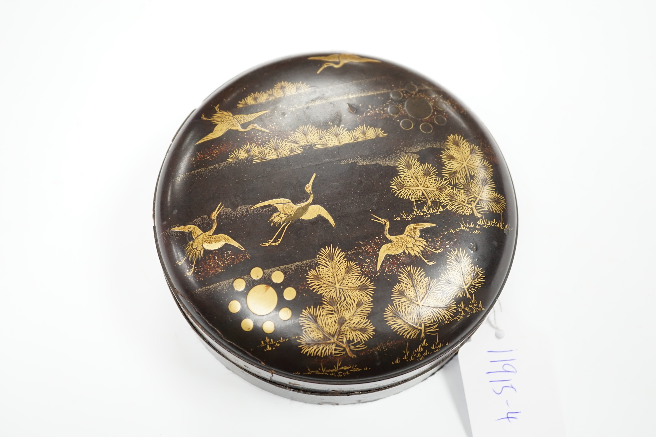 A Japanese cast mirror, housed in a lacquered case, 12cm in diameter